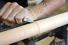 木工旋盤で削って丸脚を作っているところ