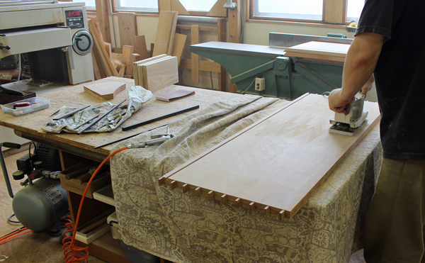 オービタルサンダーによるキャビネットの板の仕上げの画像